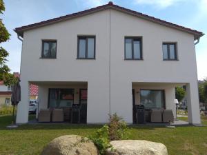 a white house with two boulders in front of it at Reusenhaus Nord in Breege