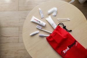 a table with toothbrushes and a red bag on it at RedDoorz near Universitas Widyagama Malang in Malang