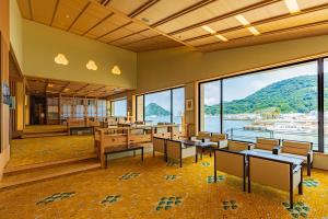 a classroom with tables and chairs and a view of the water at Izu Mitohama Shotokan in Numazu