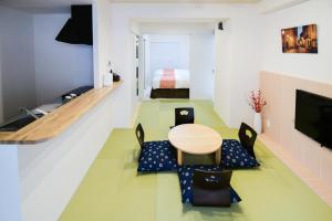 a room with a table and chairs and a bed at momo premium 401 in Sapporo