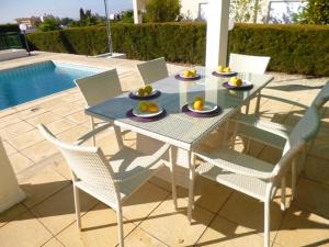 a table and chairs with food on it next to a pool at Villa Magnolia in Coral Bay