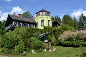 a house with a tower on top of a garden at Willa Podhale in Falsztyn