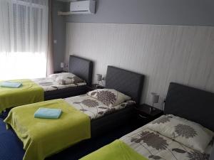 Habitación con 2 camas con sábanas verdes en H-Odra Nowa Sól, en Nowa Sól