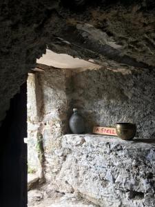 una pared de piedra con un jarrón sentado en un estante en ,A cantinella, une cave a fromage au centre corse, en Santa-Lucia-di-Mercurio