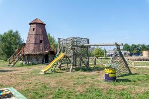a playground with a slide and a water tower at Atomiņi in Aucugals