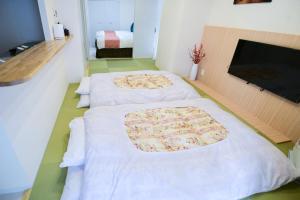 a room with three beds with white sheets and a fireplace at momo premium 401 in Sapporo