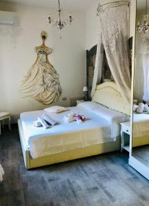 オリスターノにあるDomo All'Antico Borgoのベッドルーム1室(ベッド2台、シャンデリア付)