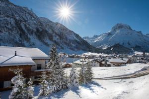 a village covered in snow with mountains in the background at Nidus Luxury Apartments in Lech am Arlberg