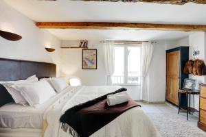 a bedroom with a large bed and a window at Heart Of Valbonne in Valbonne