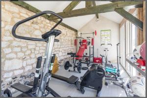 a gym with several exercise bikes in a room at Grande villa d'exception en Normandie tennis, piscine, jacuzzi, salle de fitness in Muids