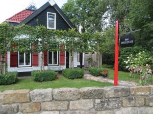 una casa con un cartel frente a una pared de piedra en B&B Singelstate, en Gorredijk