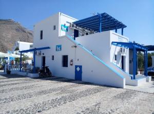 un edificio blanco con escaleras azules en el lateral en Studios Apartments Kapetanios, en Perissa