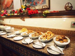 a buffet with many plates of food on a table at Hotel Club Sunway Punta Prima in Es Pujols