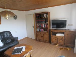 a living room with a leather couch and a television at Ferienhaus Schöne Aussicht in Esch