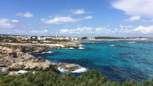 a view of the ocean from a rocky beach at Hotel Club Sunway Punta Prima in Es Pujols