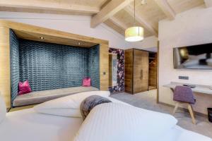 a bedroom with two white beds and a tv at Hotel Rose in Mayrhofen