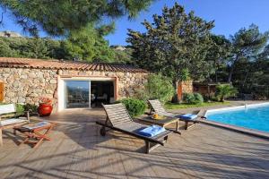 a patio with two chairs and a swimming pool at Casa Matteu in Figari