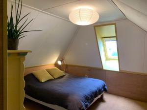 Boerderij met atelier في دالْفْسين: غرفة نوم بسرير ونافذة ومصباح