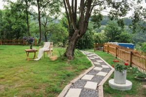 a garden with a table and a bench and a tree at Nebo nad Štiavnicou - zelená chalupa s výhľadom in Banská Štiavnica