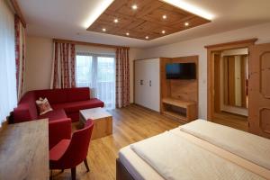 Camera con letto, divano e TV. di Alpenhotel Ernberg a Reutte
