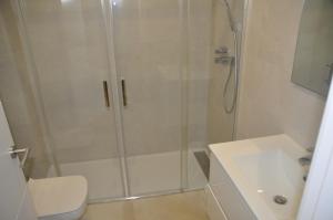 a bathroom with a shower with a toilet and a sink at APARTAMENTO ICEBERG TARIFA in Tarifa +4 photos