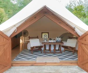 a room with a tent with a table and chairs at The Birder's Lodge Khao Yai in Pak Chong