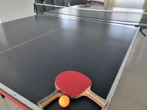 a ping pong table with a red ping pong racket at Pensiunea Platinum in Târgu Jiu