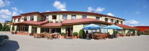a building with tables and umbrellas in front of it at Motel Pintal in Gorzów Wielkopolski