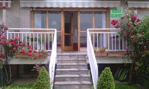a staircase leading to a house with flowers on it at Adosado con Piscina y Jardín Privado en Laredo a 100 mtrs de la playa in Laredo