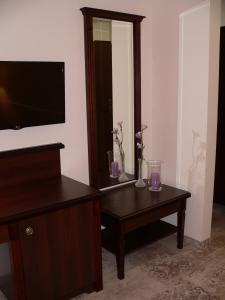 a living room with a tv and a table with flowers on it at Hotel Biały Dwór in Okuninka