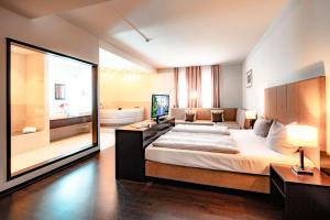 a large bedroom with a large bed and a bathroom at Friendly Cityhotel Oktopus in Siegburg