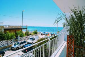 a balcony with a view of the beach and the ocean at TORRE LAPILLO Fronte Mare in Centro con parcheggio coperto in Torre Lapillo
