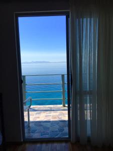 una puerta a un balcón con vistas al océano en Ria mare, en Qeparo