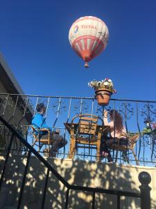 a hot air balloon flying over a balcony with tables and chairs at Capiedra Hotel in Uchisar