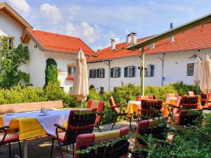 une terrasse avec une table, des chaises et un parasol dans l'établissement Landgasthof "Wilder Mann", à Innsbruck