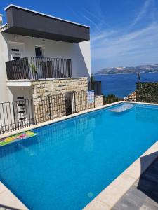 a large blue swimming pool next to a building at Residence Alpha Apartments in Cavtat