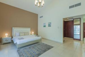 a large bedroom with a bed and a chandelier at Houst Holiday Homes - Green Commnity West in Dubai