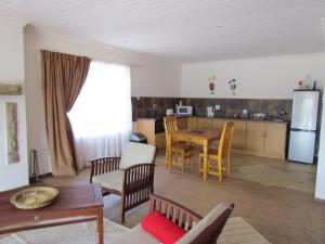 a kitchen and a living room with a table and chairs at Pumula Guest Farm in Fouriesburg
