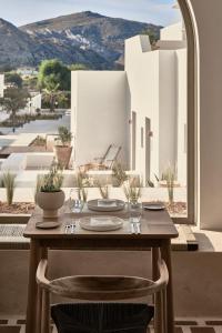 a wooden table and chair with a view of a building at Parilio, a Member of Design Hotels in Naousa