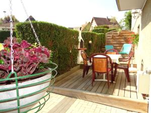 una terraza con sillas, una mesa y algunas flores en Aux oiseaux de passage en Rosheim