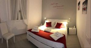 una camera da letto con un letto con cuscini rossi e una sedia di I Quattro Elementi a Marina di Mancaversa