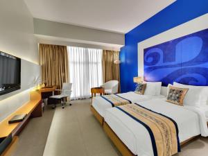 ムンバイにあるThe Fern Residency Mumbaiのベッド2台とテレビが備わるホテルルームです。