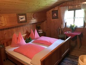 - une chambre avec un grand lit et des oreillers rouges dans l'établissement Senninger Alm, à Hollersbach im Pinzgau