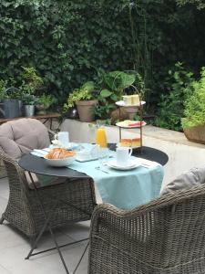 ニームにあるChambre côté jardinの青いテーブルクロスと椅子2脚付きのテーブル