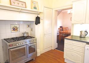 a kitchen with a stove and a dining room at Bury Villa - 7 bedrooms sleeping 18 guests in Gosport