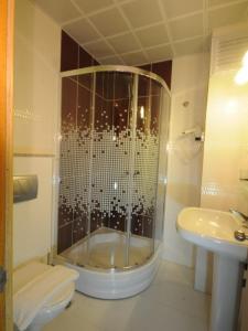 y baño con ducha, aseo y lavamanos. en Rosy Hotel Marmaris, en Marmaris