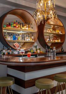 a bar with two mirrors on the wall and two stools at AxelBeach Miami South Beach - Adults Only in Miami Beach