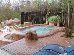 a small pool in a yard with a brick patio at Tranquil Nest in Hazyview