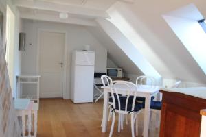 uma cozinha com uma mesa e um frigorífico branco em Troense Bed and Breakfast by the sea em Svendborg