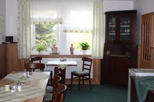 a dining room with two tables and a window at Ferienhof Koch in Oedelsheim